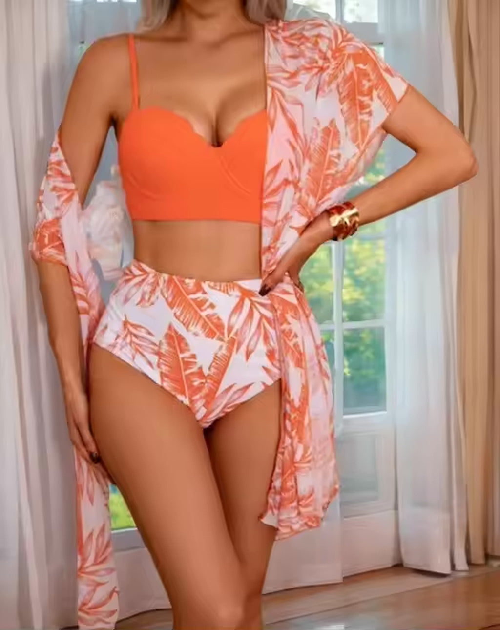 Woman wearing orange sweetheart bikini top with coral leaf-print high-waist bikini bottom and matching cover-up.