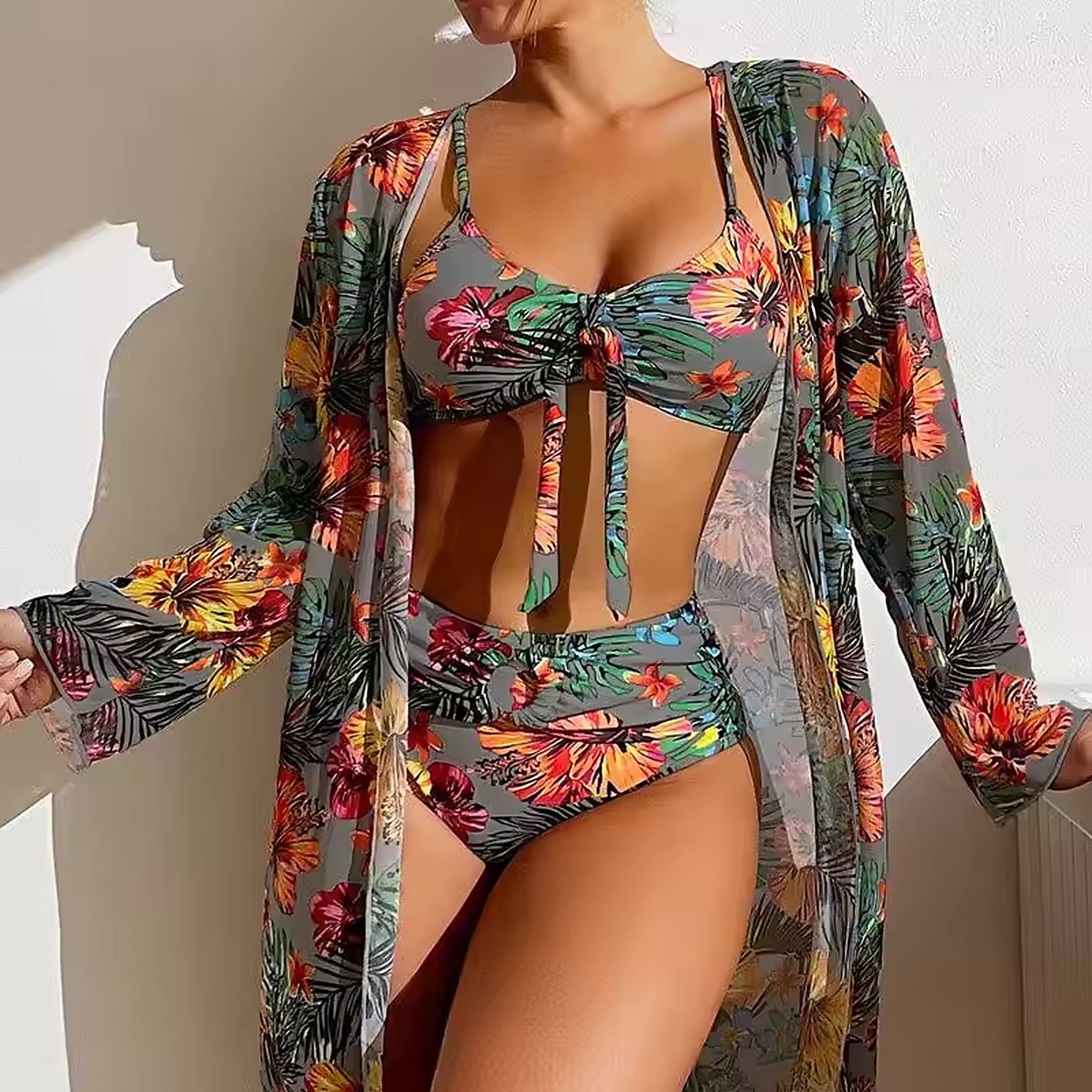Tropical floral bikini with vibrant multicolored flowers on gray background, paired with matching sheer cover-up cardigan.