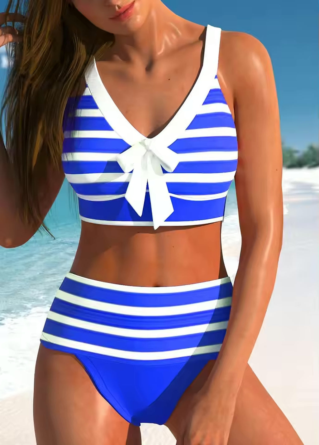 Blue and white striped bikini with bow detail, worn on sunny beach with ocean backdrop