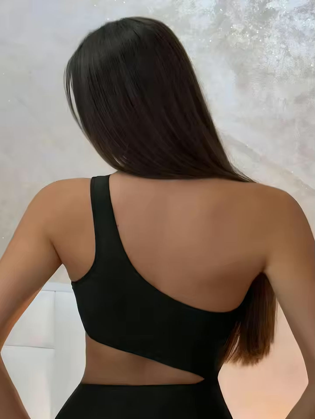 Woman wearing black Malibu Muse one-piece swimsuit, rear view showing sleek design and fit