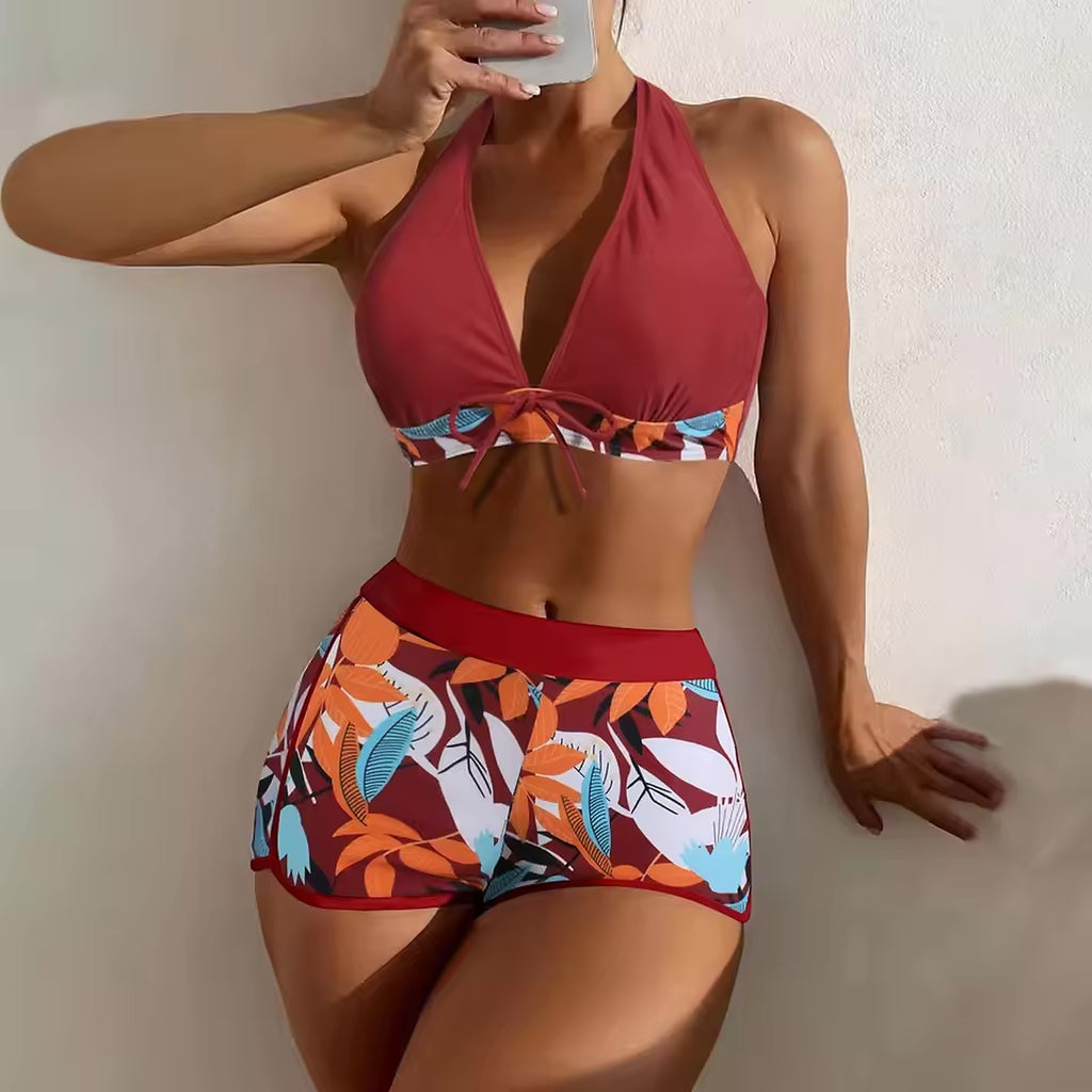 Red halter bikini top with tropical print band and matching patterned shorts with red waistband.