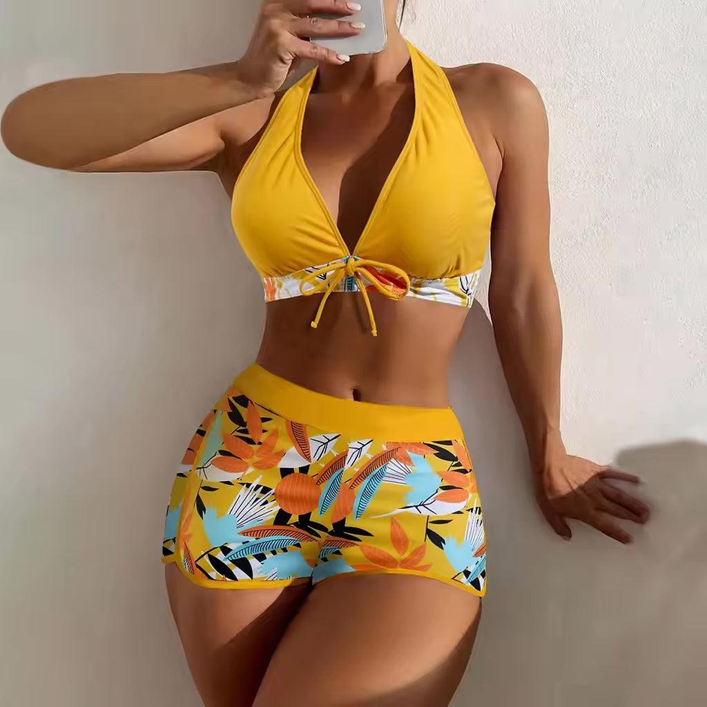 Yellow halter bikini with tropical floral print and tie-front top, colorful swim shorts with botanical design